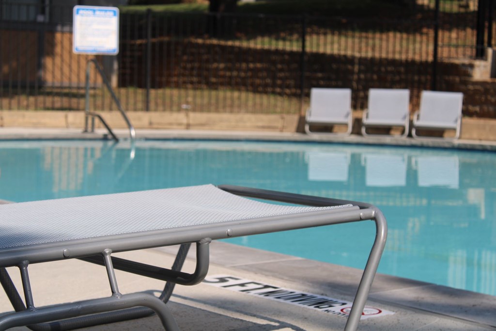 a swimming pool with a pool chair next to it